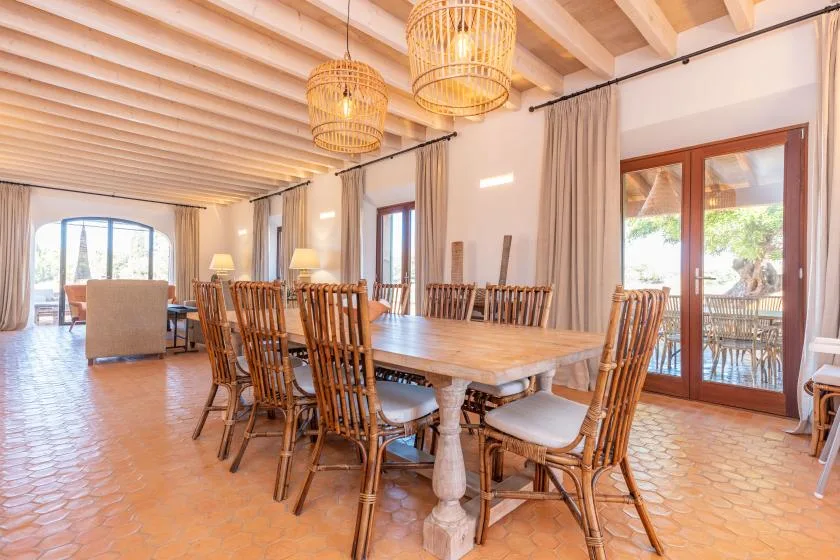 Un comedor con una mesa larga de madera y varias sillas.
