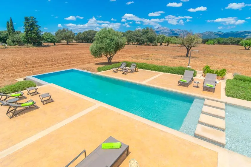 Una piscina al aire libre junto a un paisaje seco y abierto.