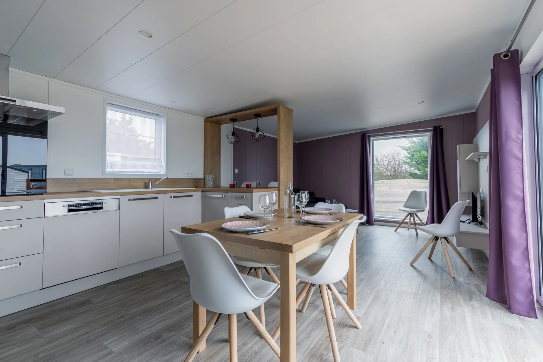 Open-plan kitchen and dining area with a table and chairs.