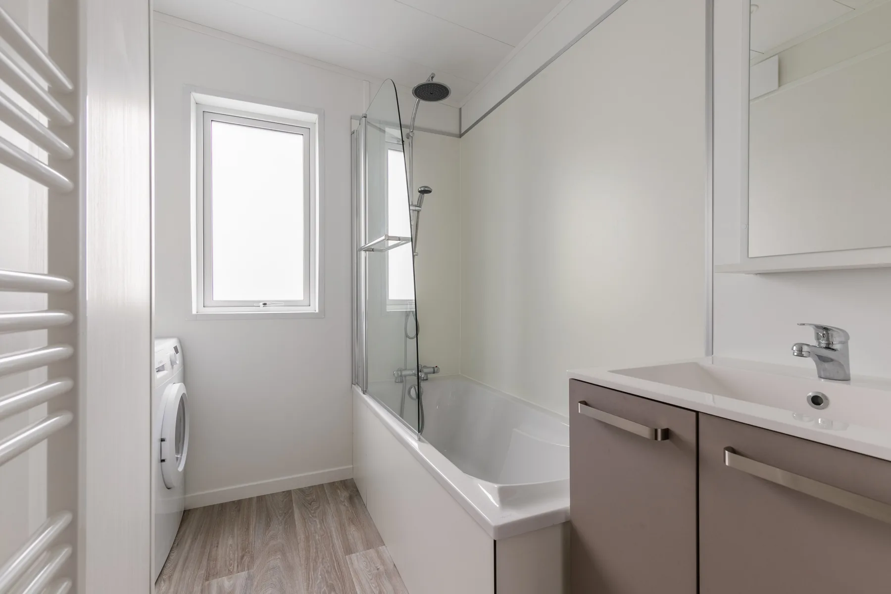 A bright bathroom with a bathtub, shower, and sink vanity.