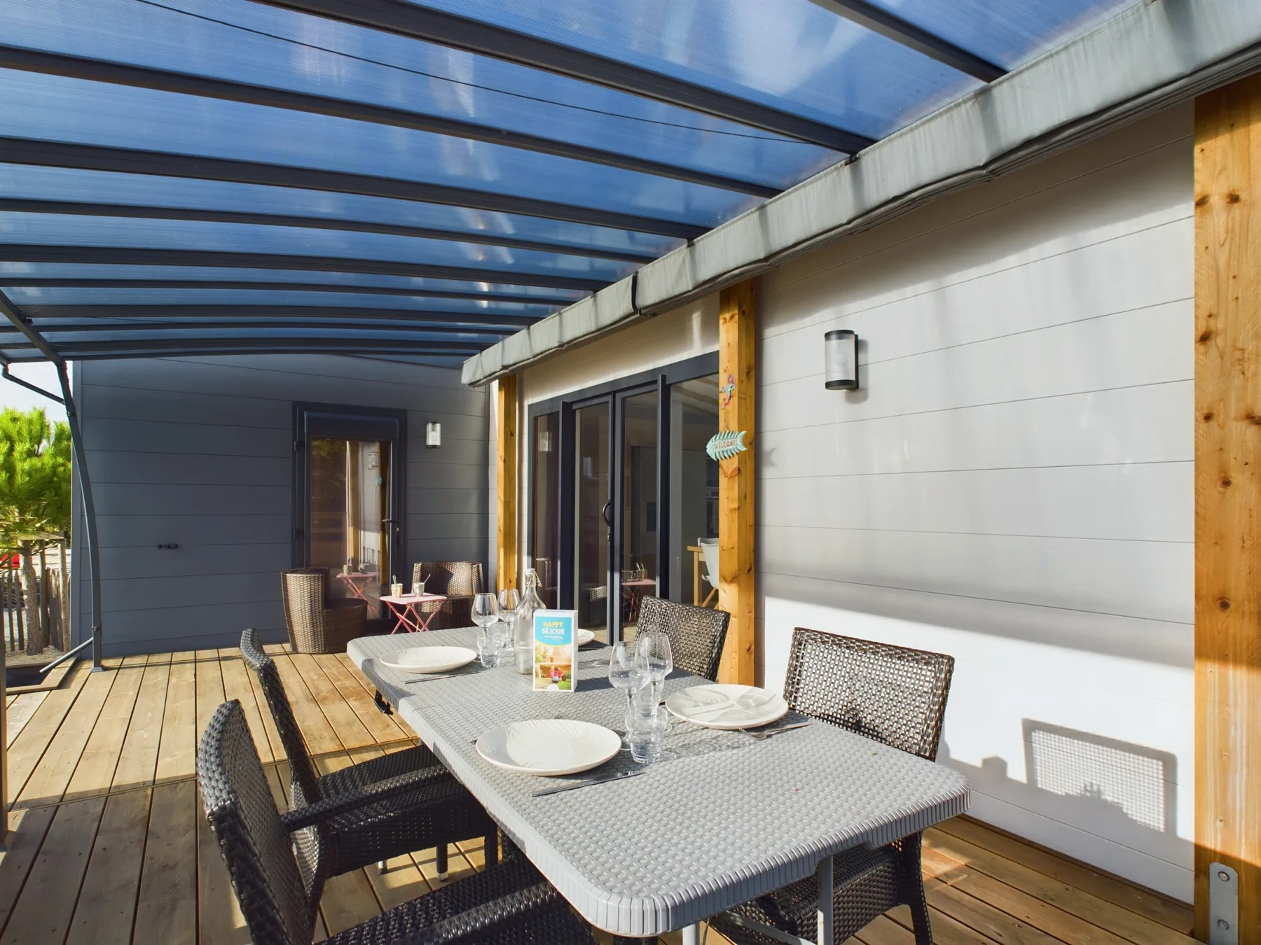 A covered outdoor dining area with a table beside sliding glass doors.