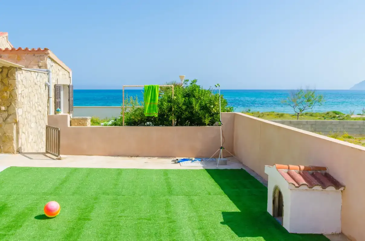 A seaside terrace with artificial turf and a view of the ocean.