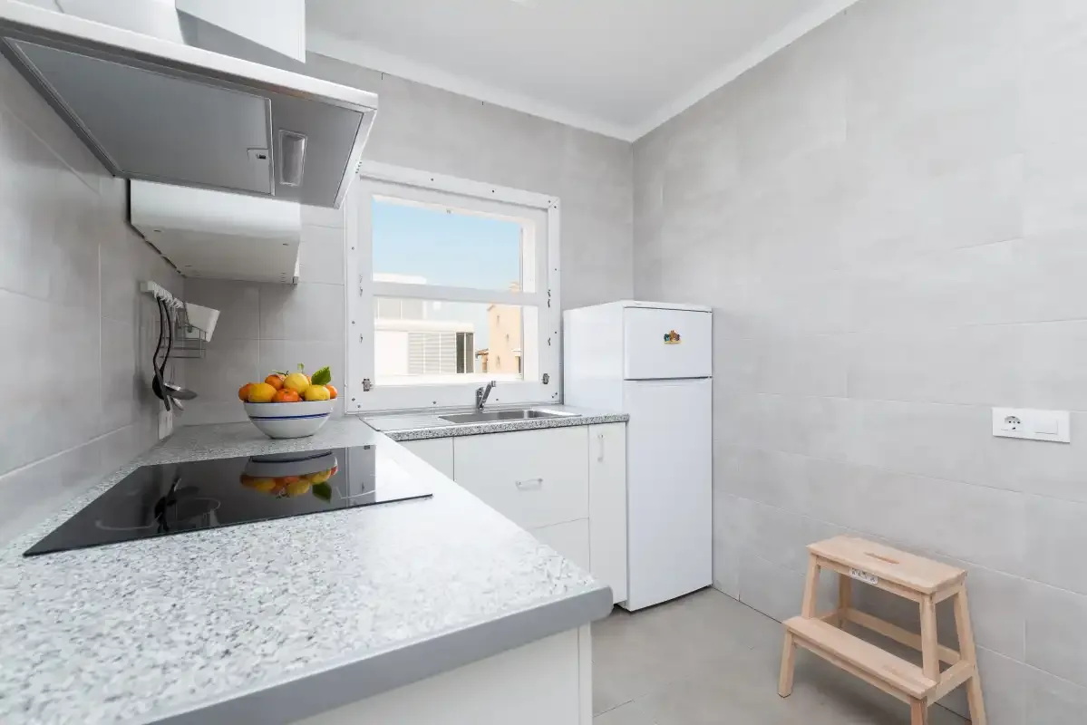 A bright kitchen with a countertop and window.
