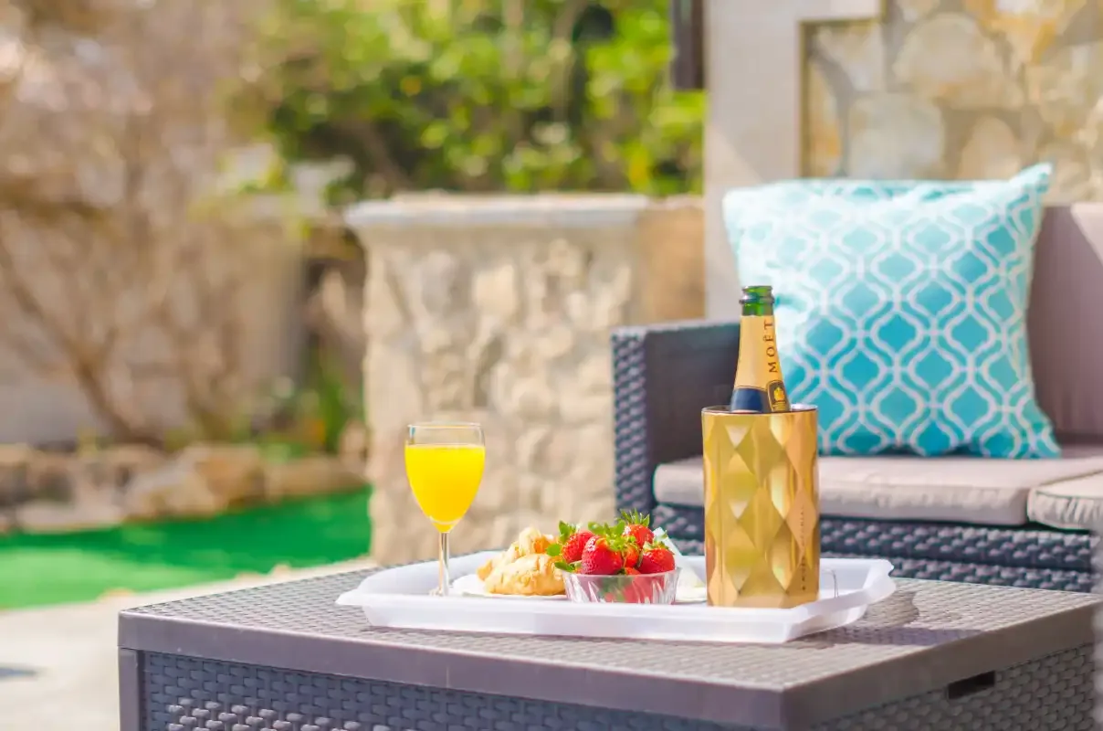 An outdoor patio seating area with drinks and fruit on a table.