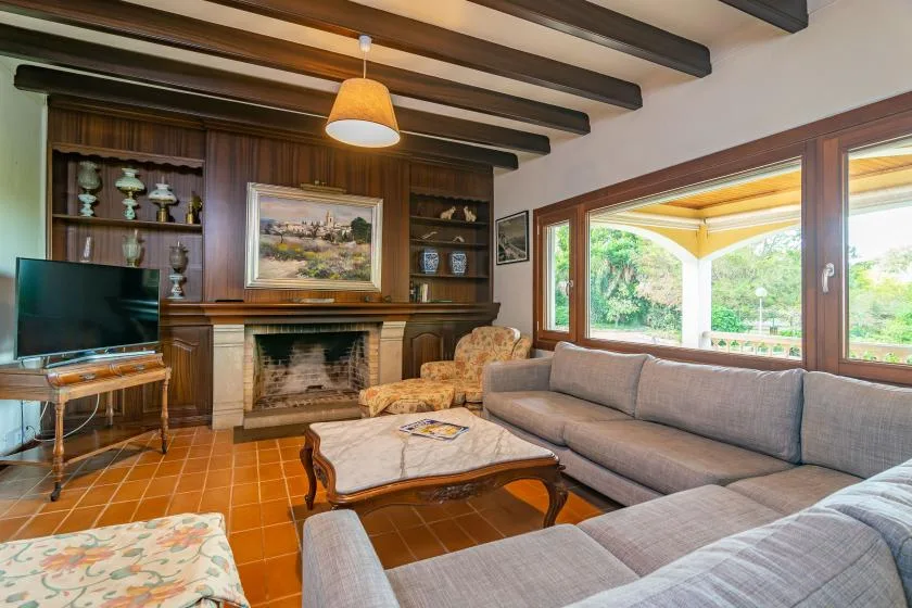 A living room with seating around a coffee table beside a fireplace.
