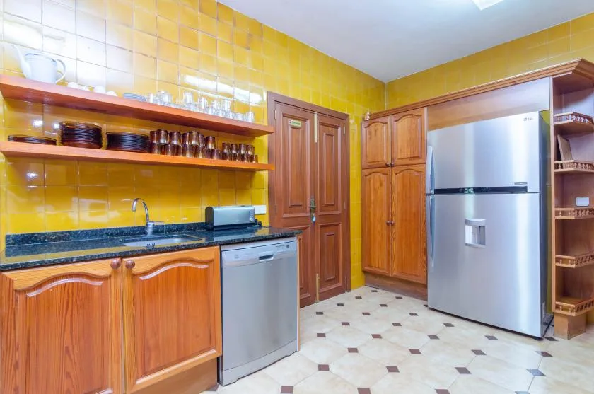 A kitchen with wooden cabinets, a countertop, and a refrigerator.