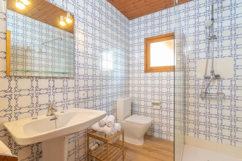A tiled bathroom with a sink, toilet, and shower.