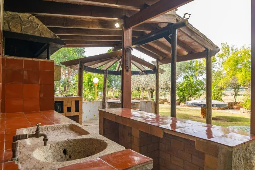 An open-air cooking area with tiled counters overlooks a garden.