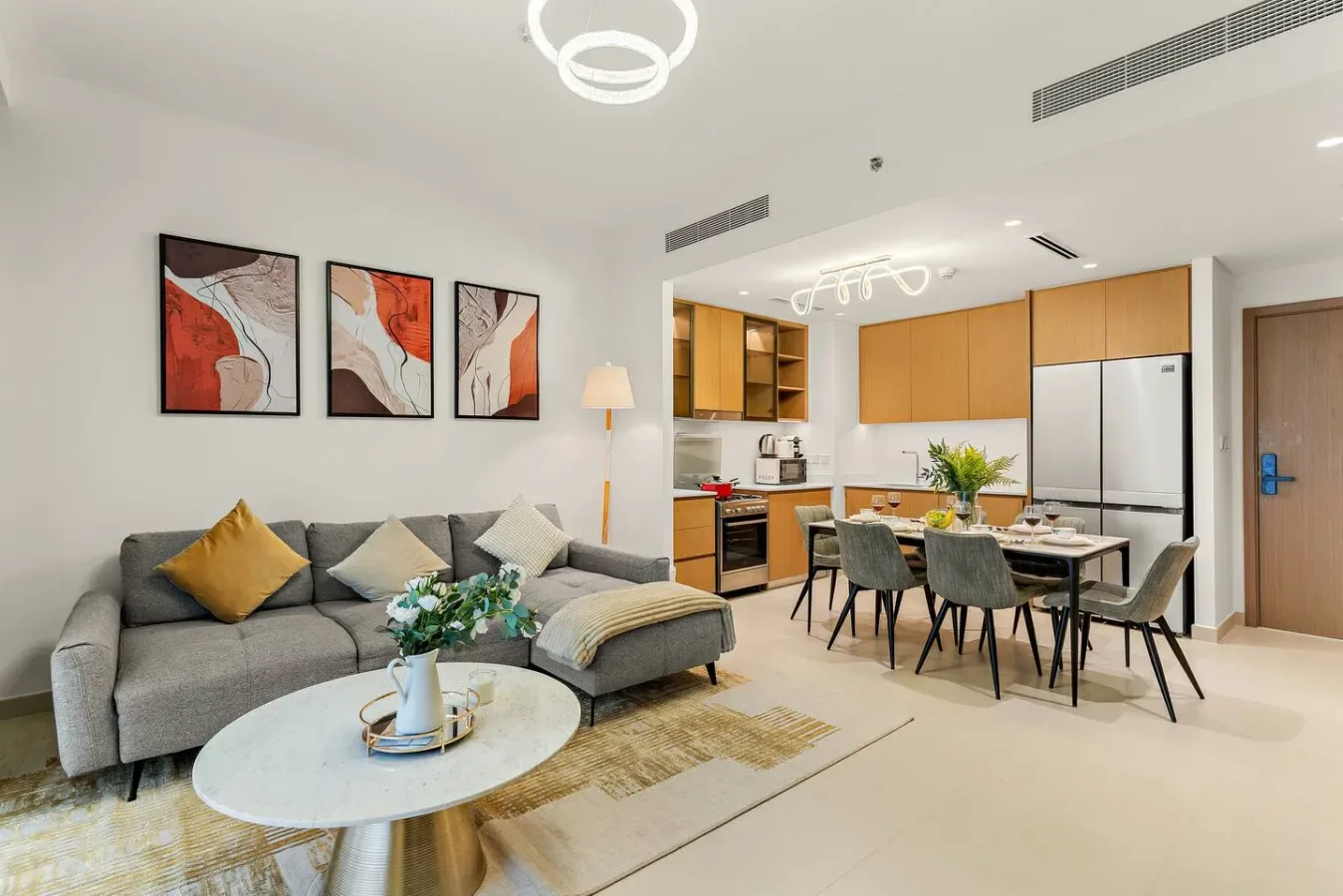 Una sala de estar y comedor se abre a una cocina, con asientos y una mesa.