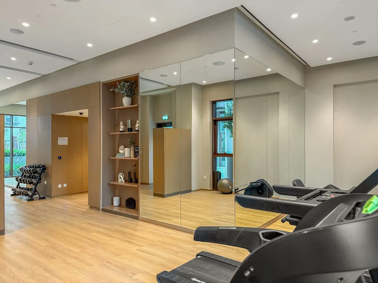 Una luminosa sala de ejercicio con equipos de entrenamiento y paredes con espejos.
