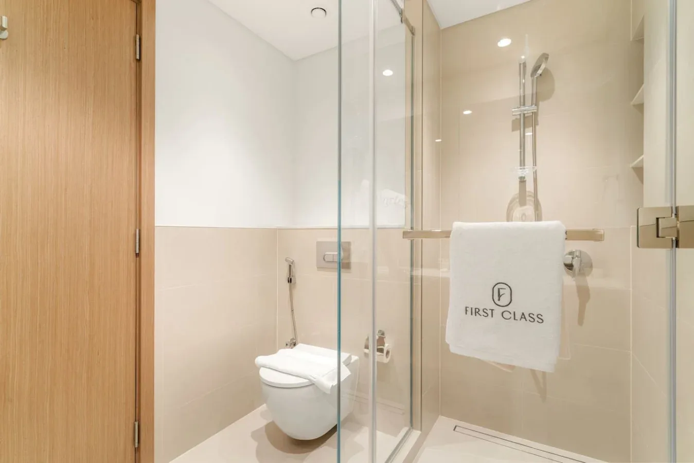 Un baño con un inodoro y una ducha con mampara de vidrio.