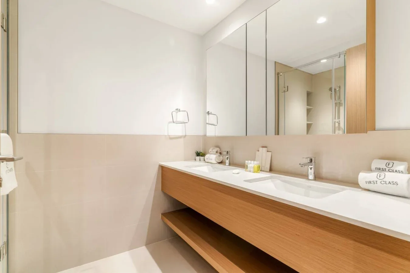 Un lavabo de baño con un fregadero largo y una pared con espejo.