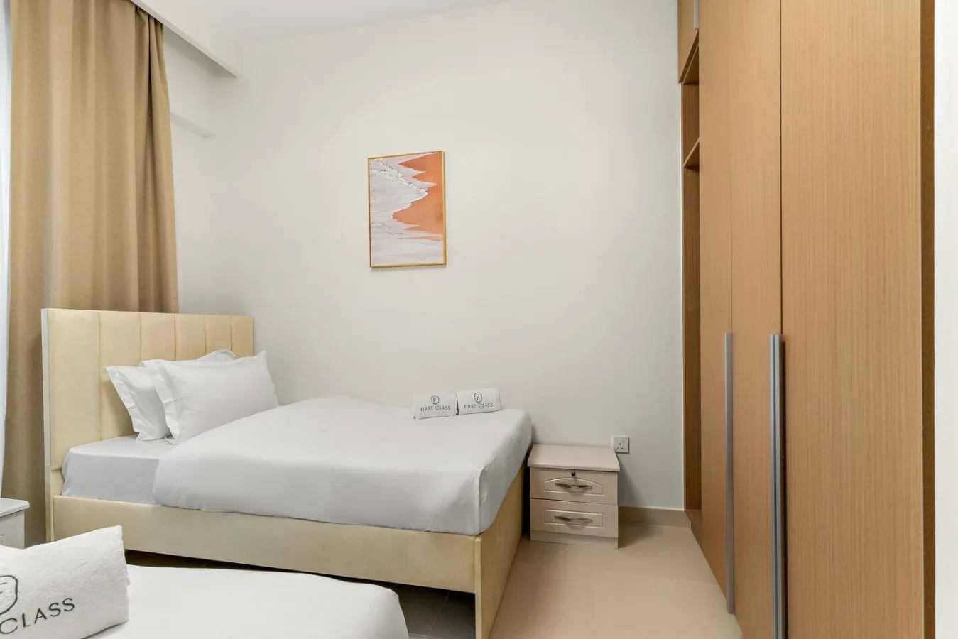 Un dormitorio con una cama tendida, una mesita de noche y un armario.