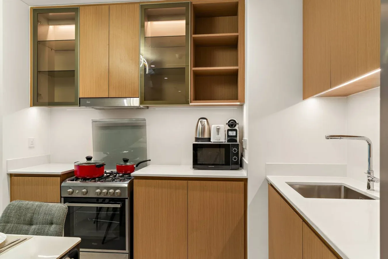 Una cocina moderna con gabinetes de madera, una estufa y un fregadero.