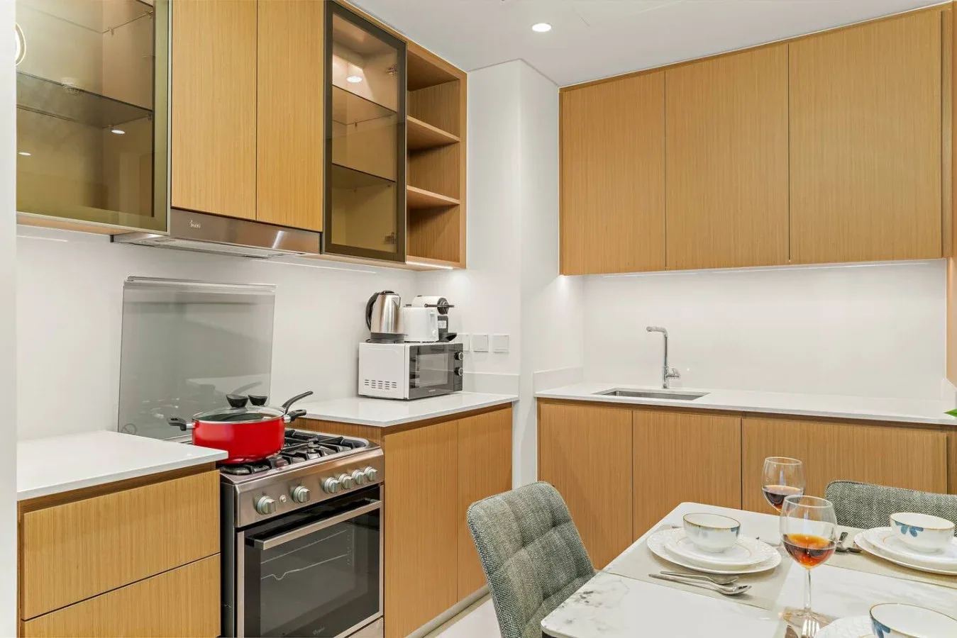 Una cocina moderna con gabinetes de madera, una estufa y una mesa de comedor.