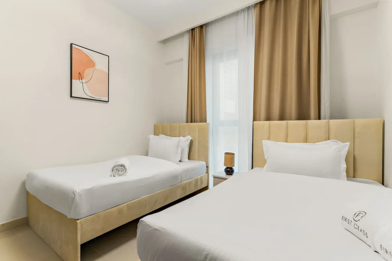 Un dormitorio con dos camas junto a una ventana con cortinas.