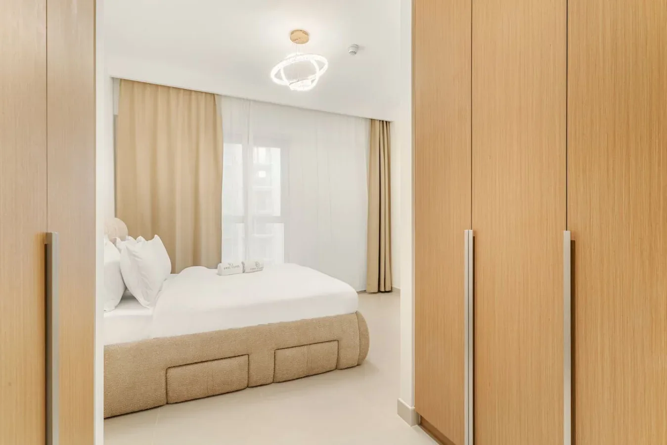 Un dormitorio con una cama junto a armarios altos de tonos madera.