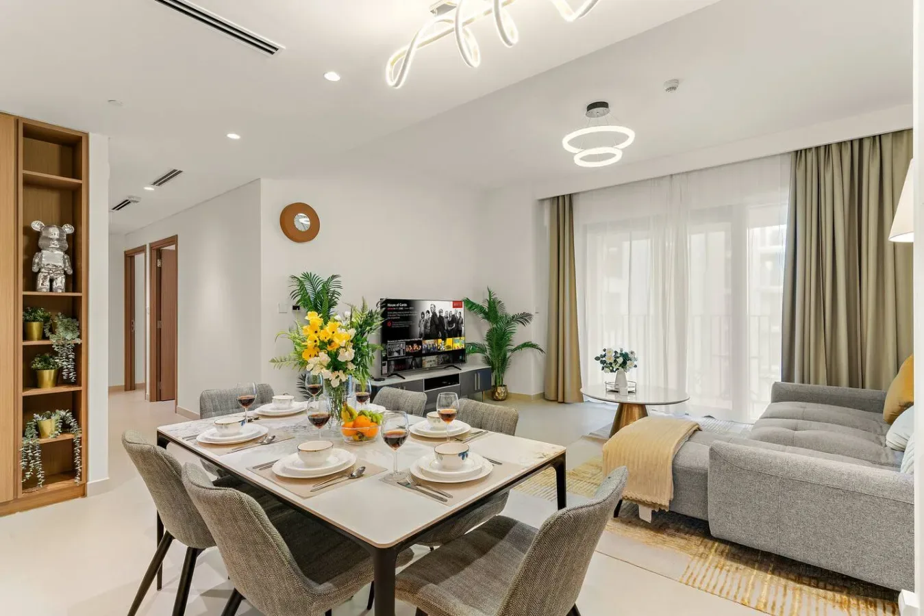Una luminosa sala de estar y comedor con asientos, un televisor y una mesa puesta.