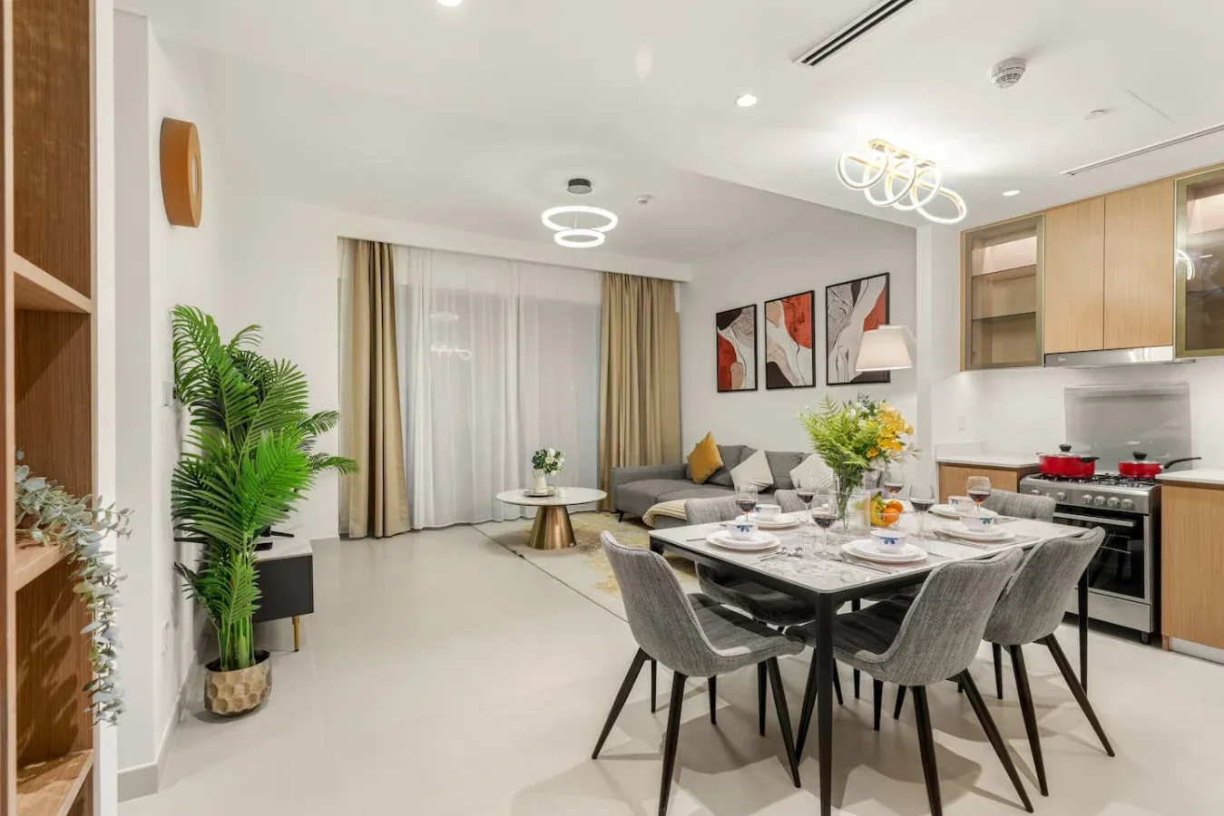 Un espacio abierto de sala y comedor con mesa, asientos y cocina.