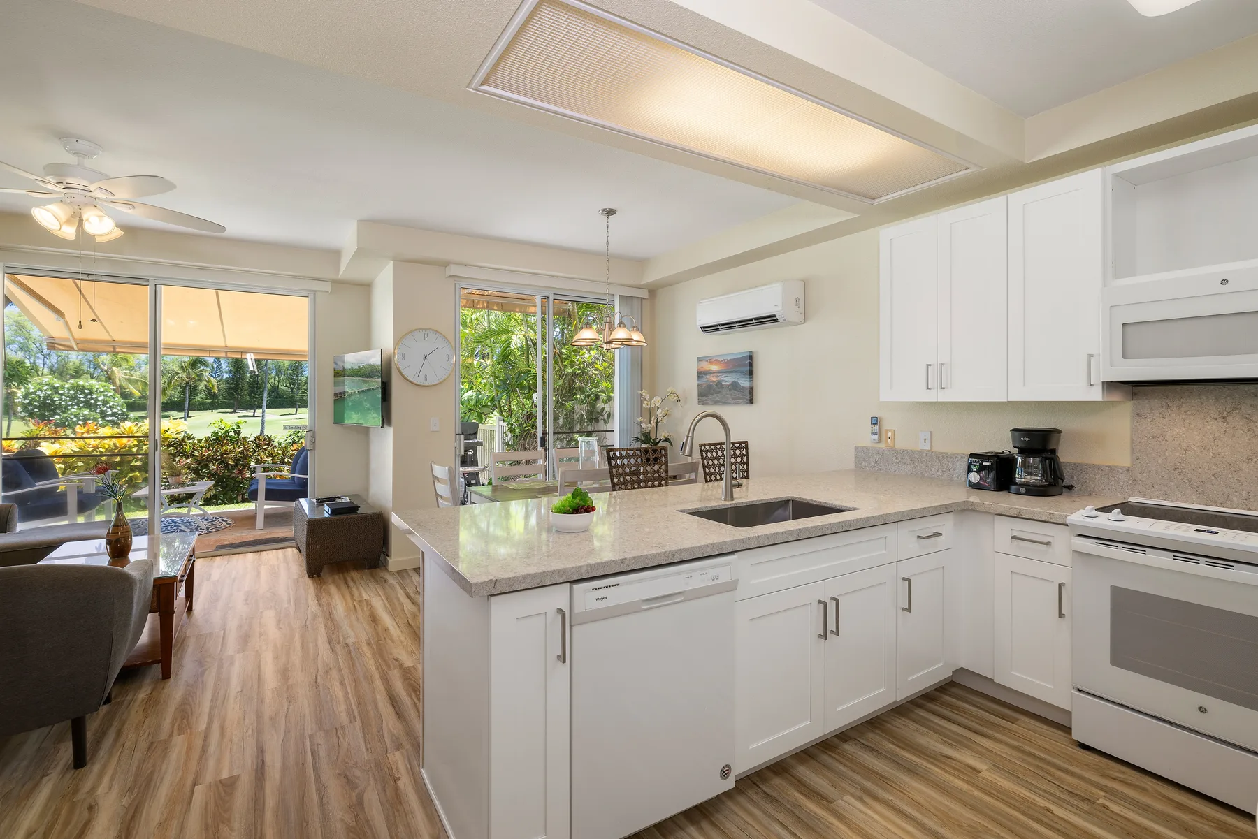 Cocina y comedor de planta abierta con una isla central y puertas corredizas de vidrio.