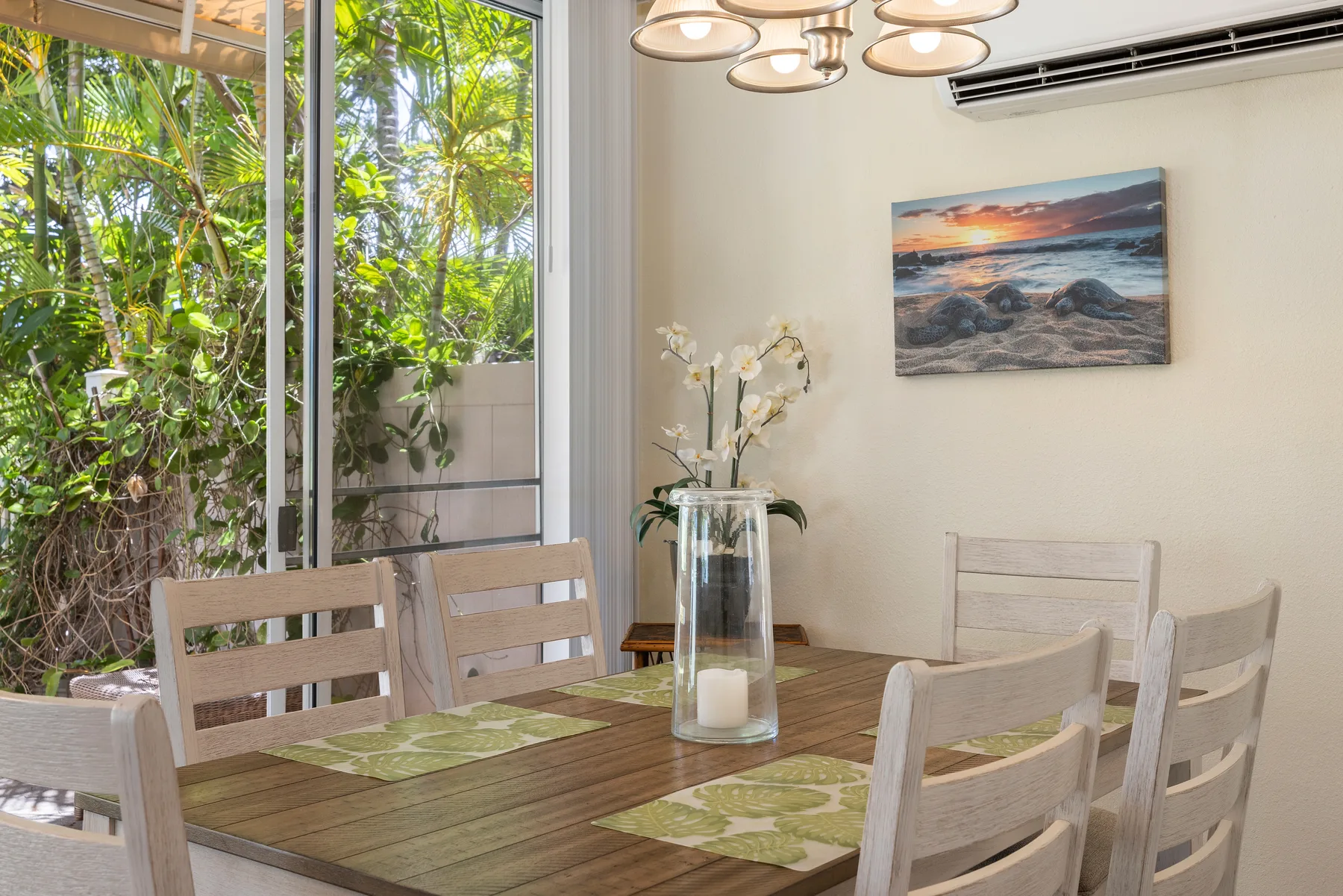 Comedor con una mesa de madera junto a grandes ventanas con vistas a la vegetación.
