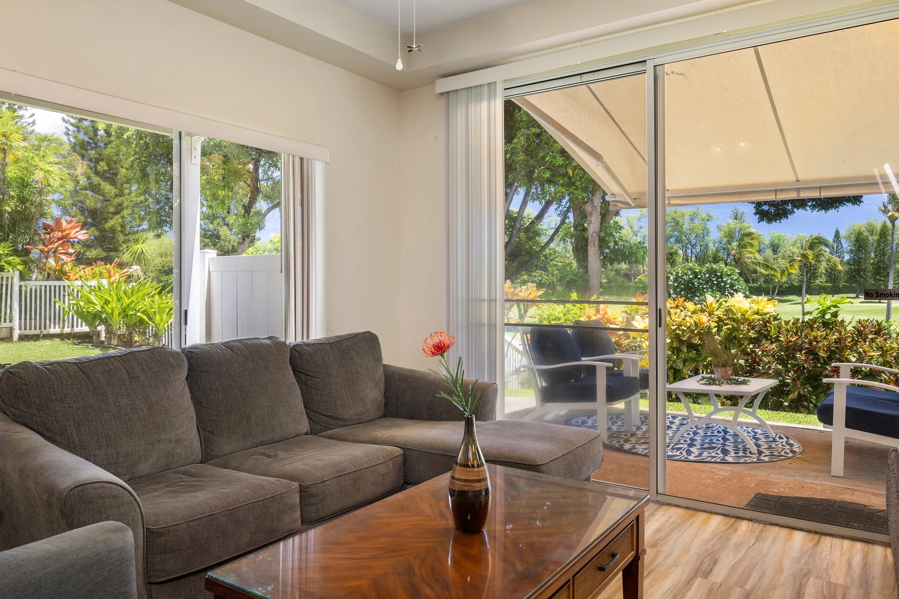 Una sala de estar con asientos y puertas de vidrio que dan a un patio con jardín.