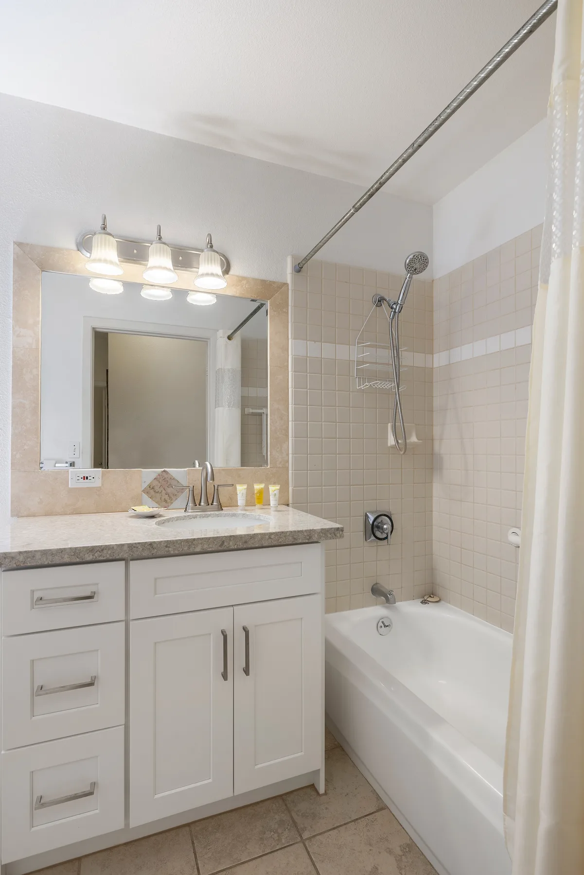 Un baño con un tocador junto a una bañera y una ducha.