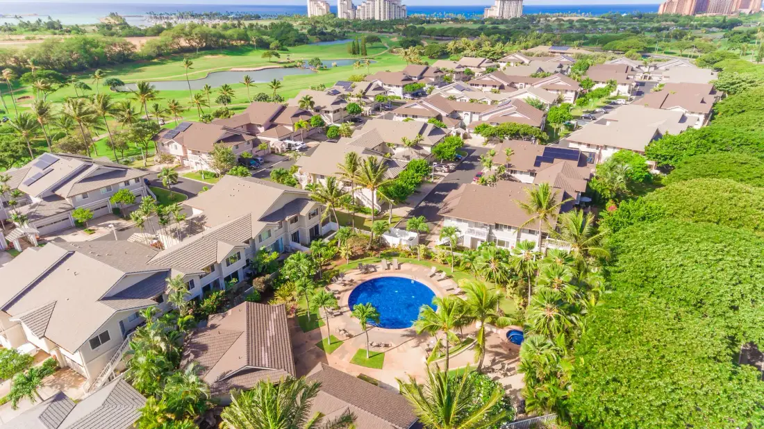 Vista aérea de un conjunto residencial con piscina y zonas verdes.
