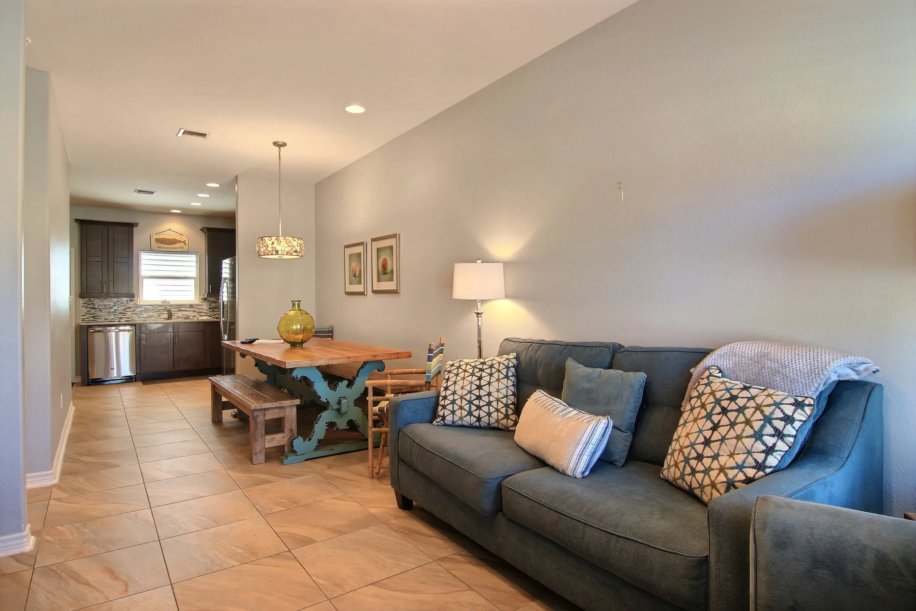 A living and dining area with a dark sofa and a wooden dining table.