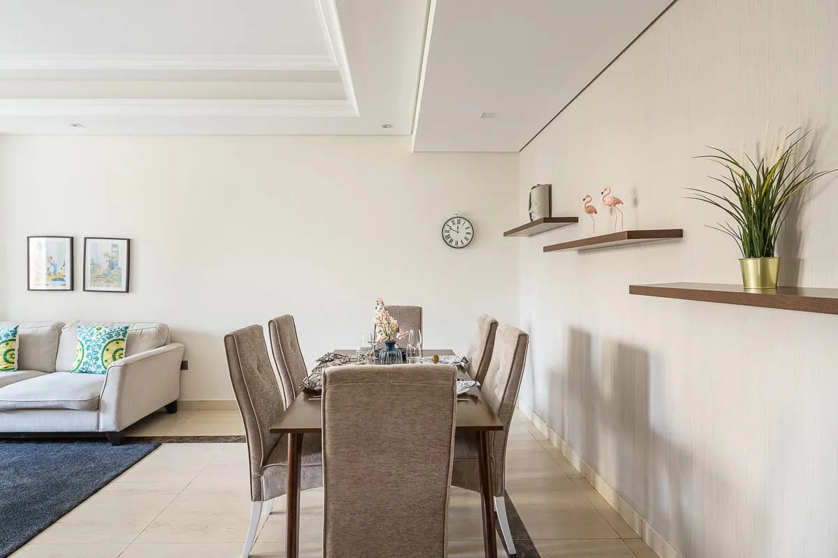 Un comedor con mesa y sillas junto a una zona de estar.