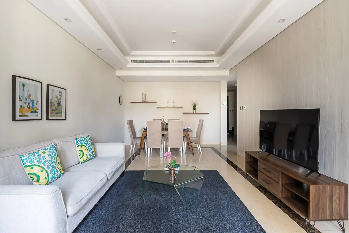 Living room with seating, a television, and a dining area.