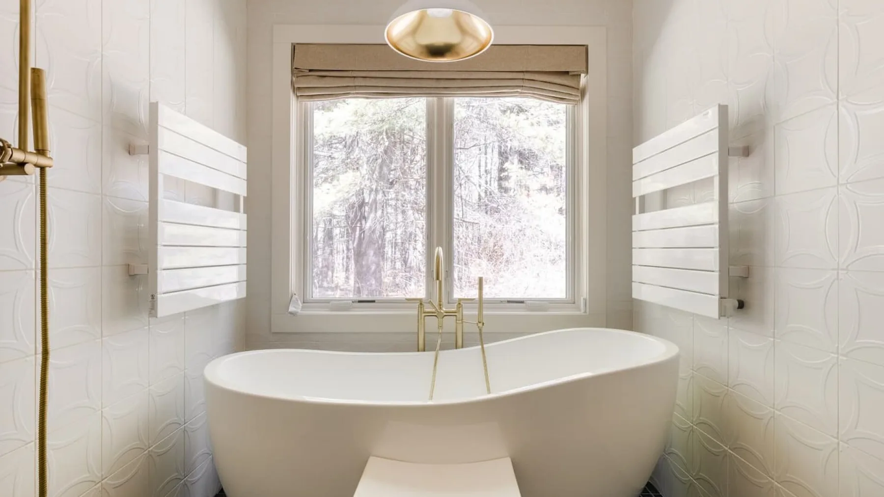 Un baño con una bañera exenta debajo de una ventana.