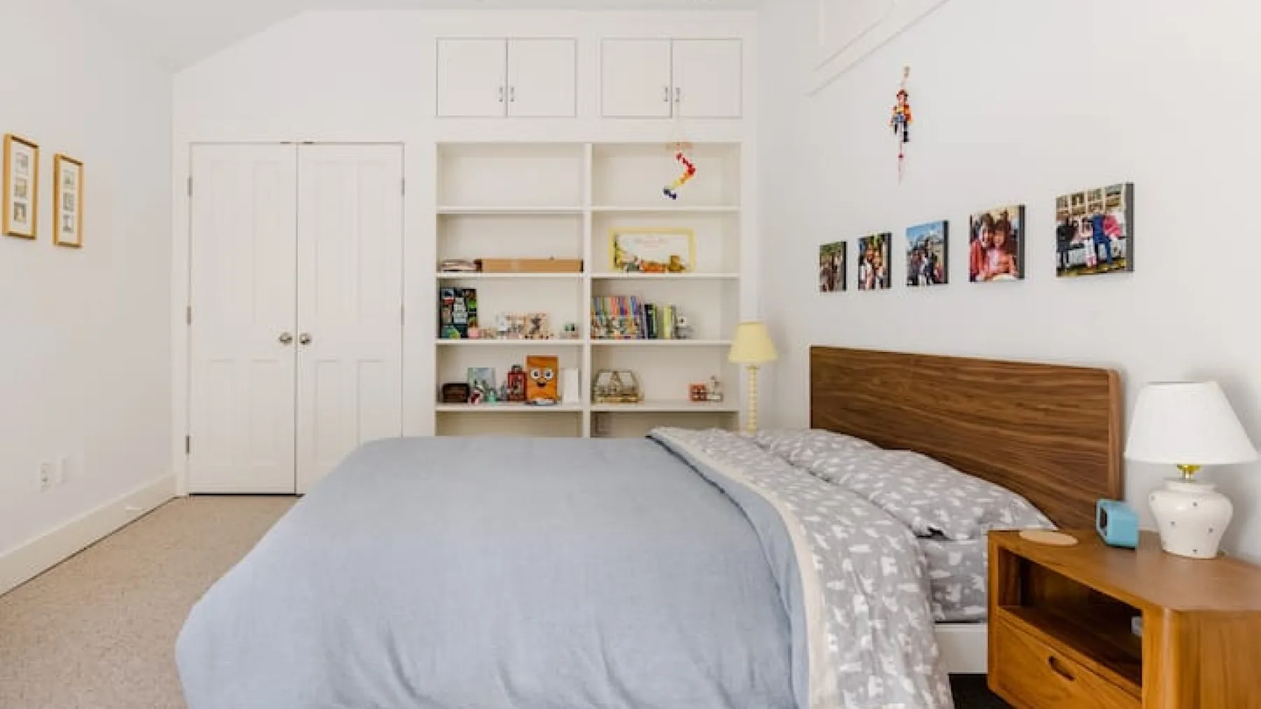 Un dormitorio con cama, cabecero de madera y estanterías empotradas.