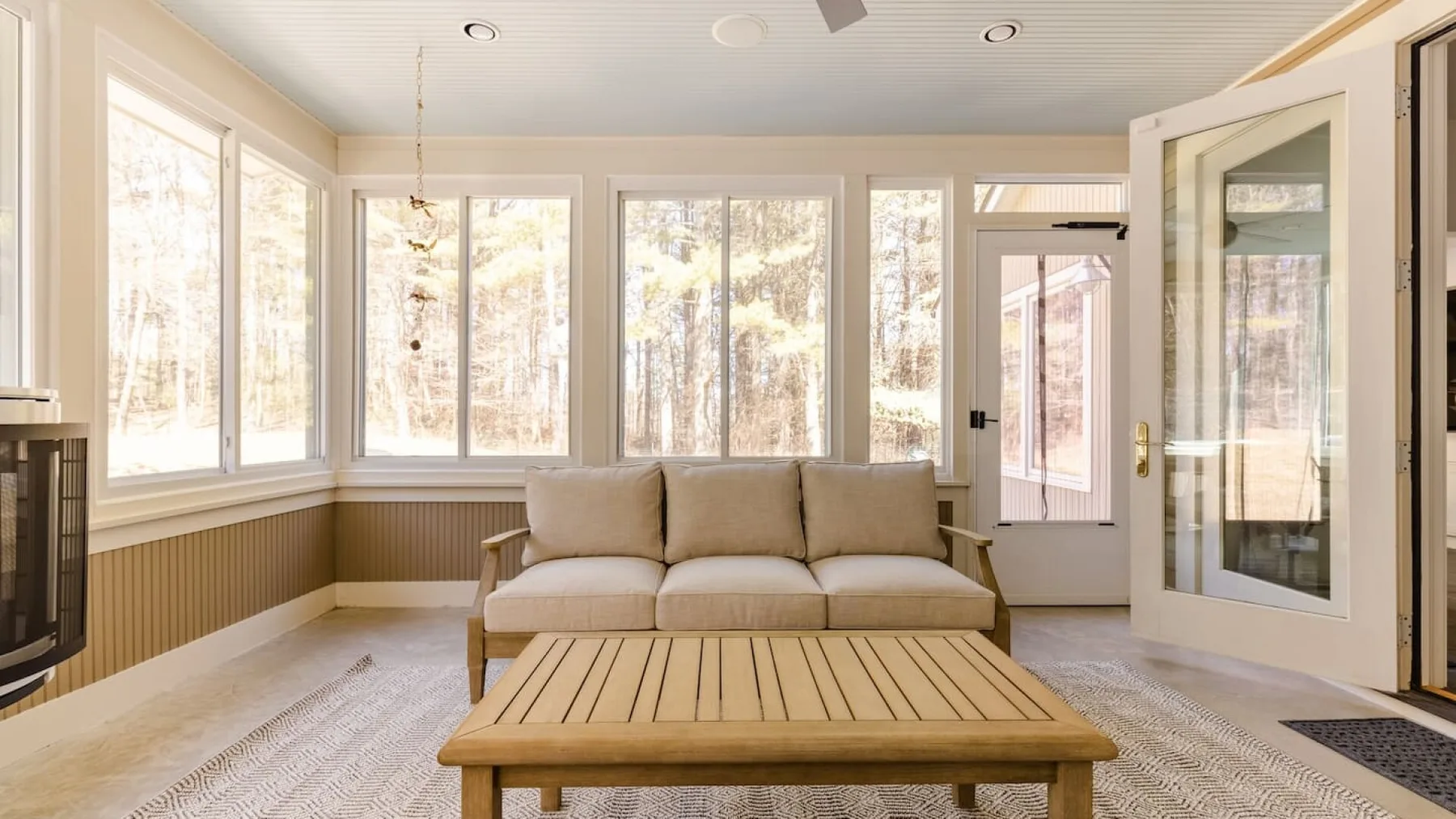 Una sala luminosa con un sofá y grandes ventanas.