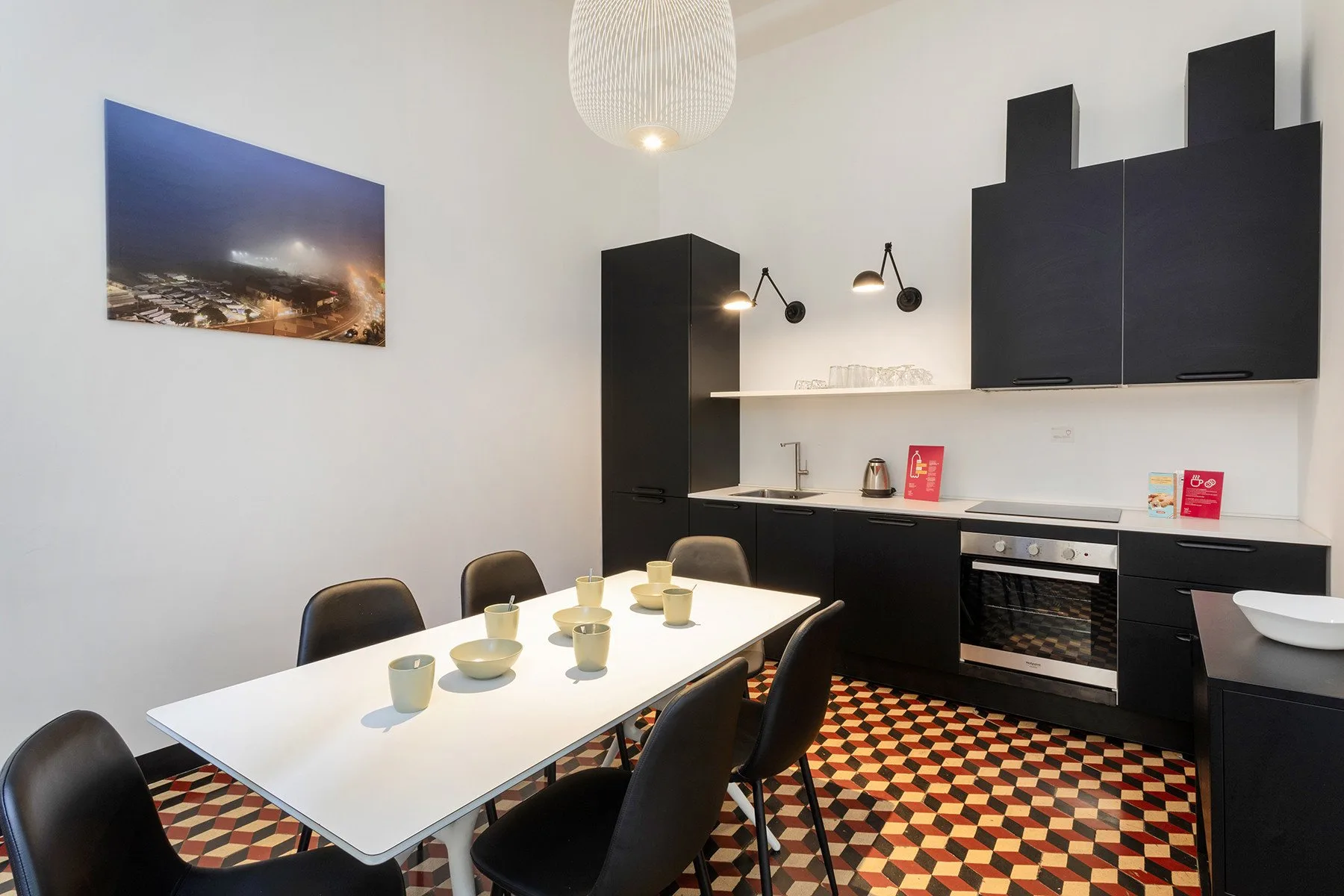 Un comedor con una mesa y sillas junto a una cocina compacta.