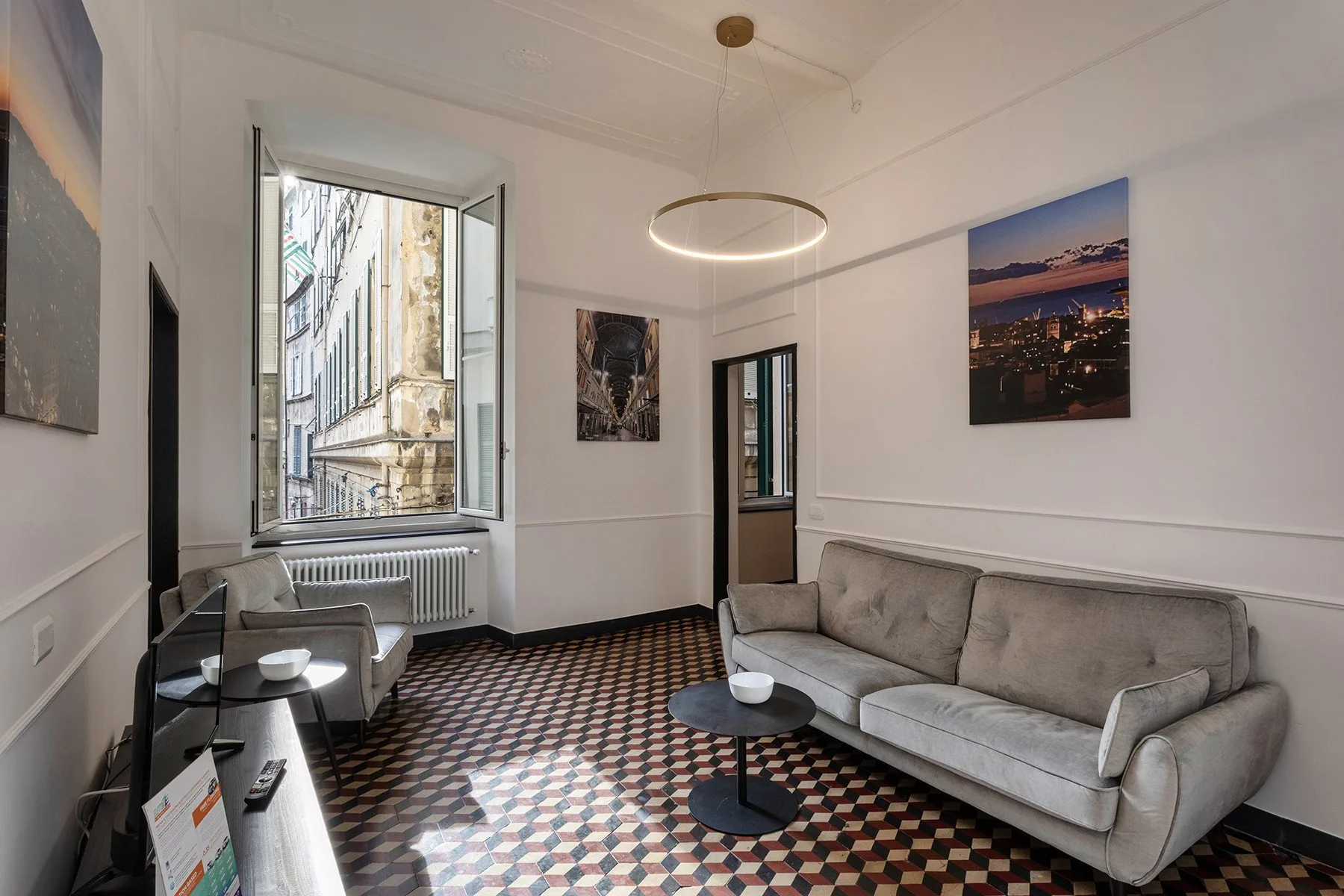 A living room with seating, a coffee table, and tall windows.