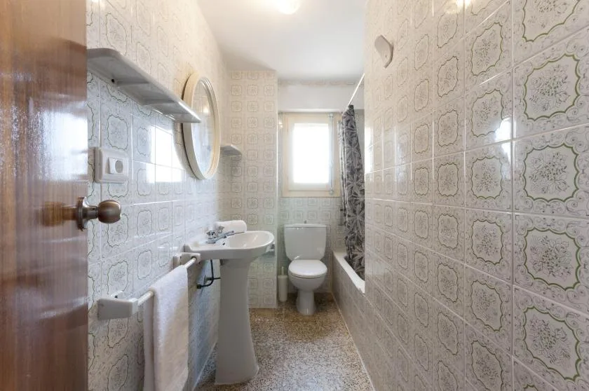A tiled bathroom with a sink, toilet, and bathtub.