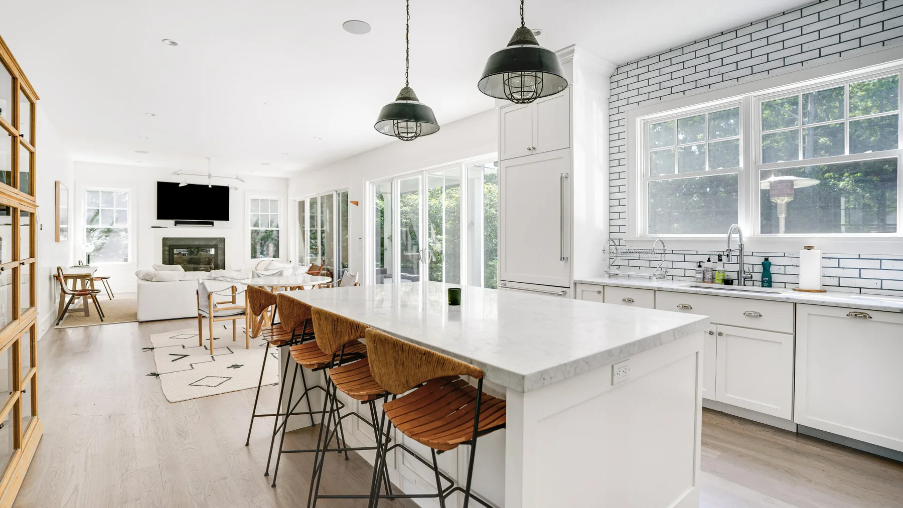Una cocina luminosa con una isla larga y asientos de madera.