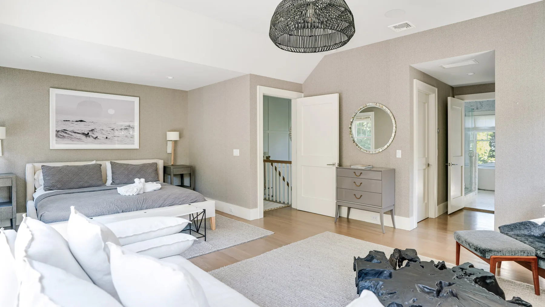 Un dormitorio con una cama, una cómoda y puertas abiertas.