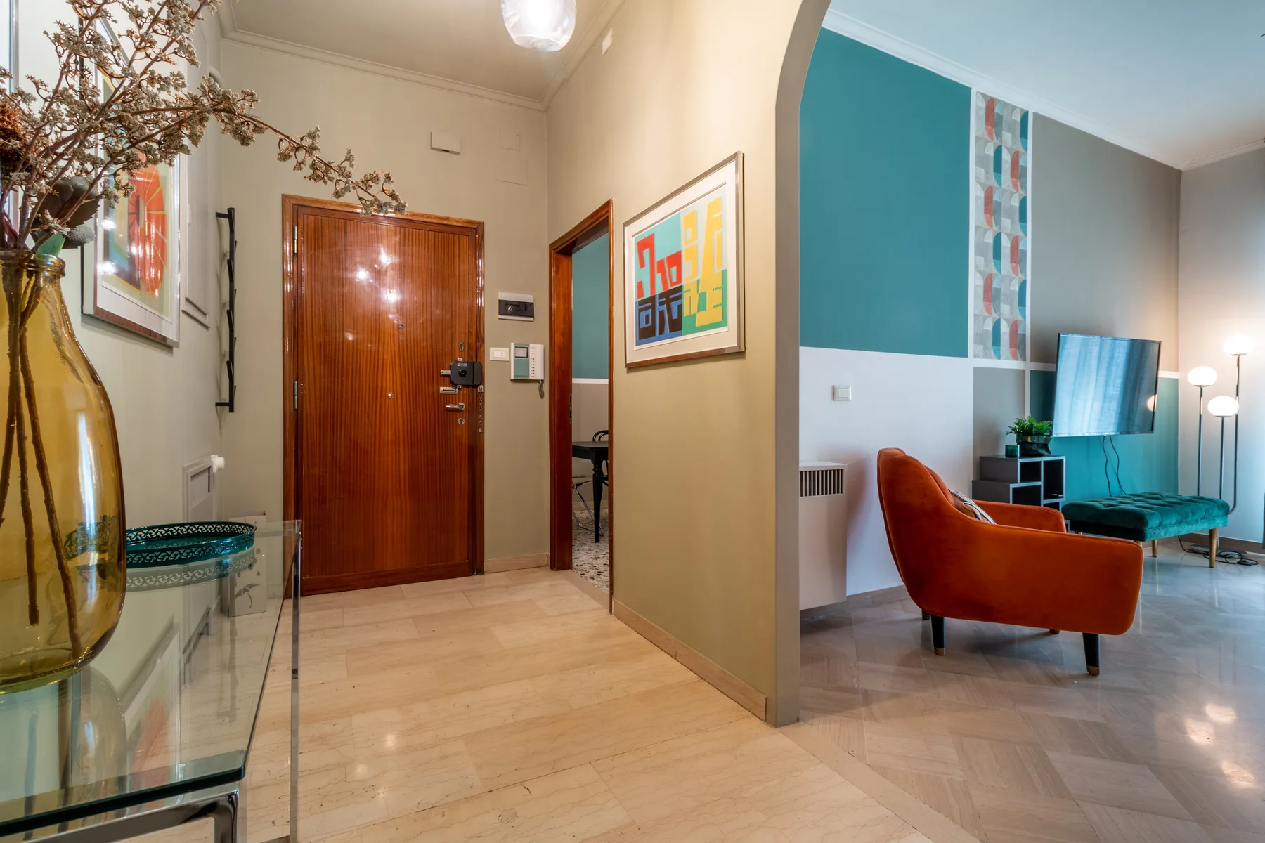 Un recibidor se abre a una sala de estar con asientos coloridos.