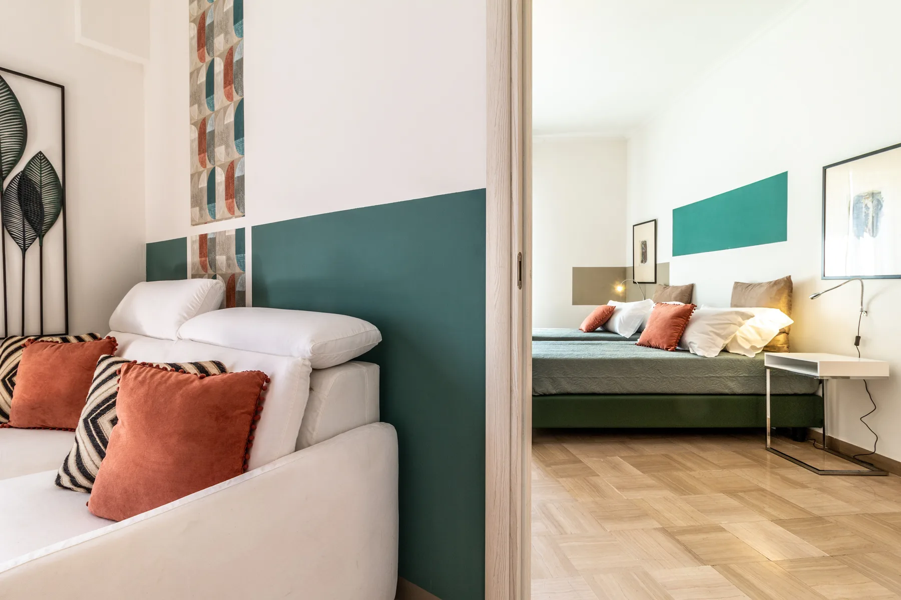 Un dormitorio luminoso con una cama, cojines de colores y una zona de estar.