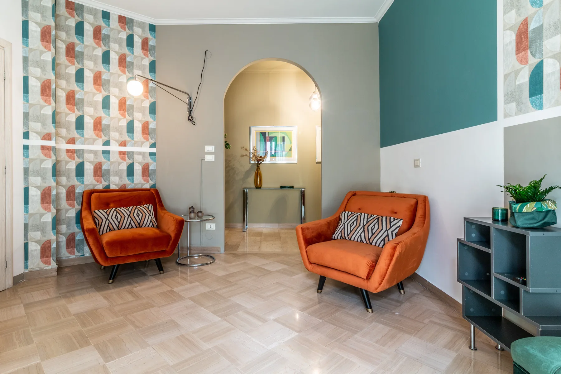 Una sala de estar con asientos naranjas y paneles de pared estampados y coloridos.