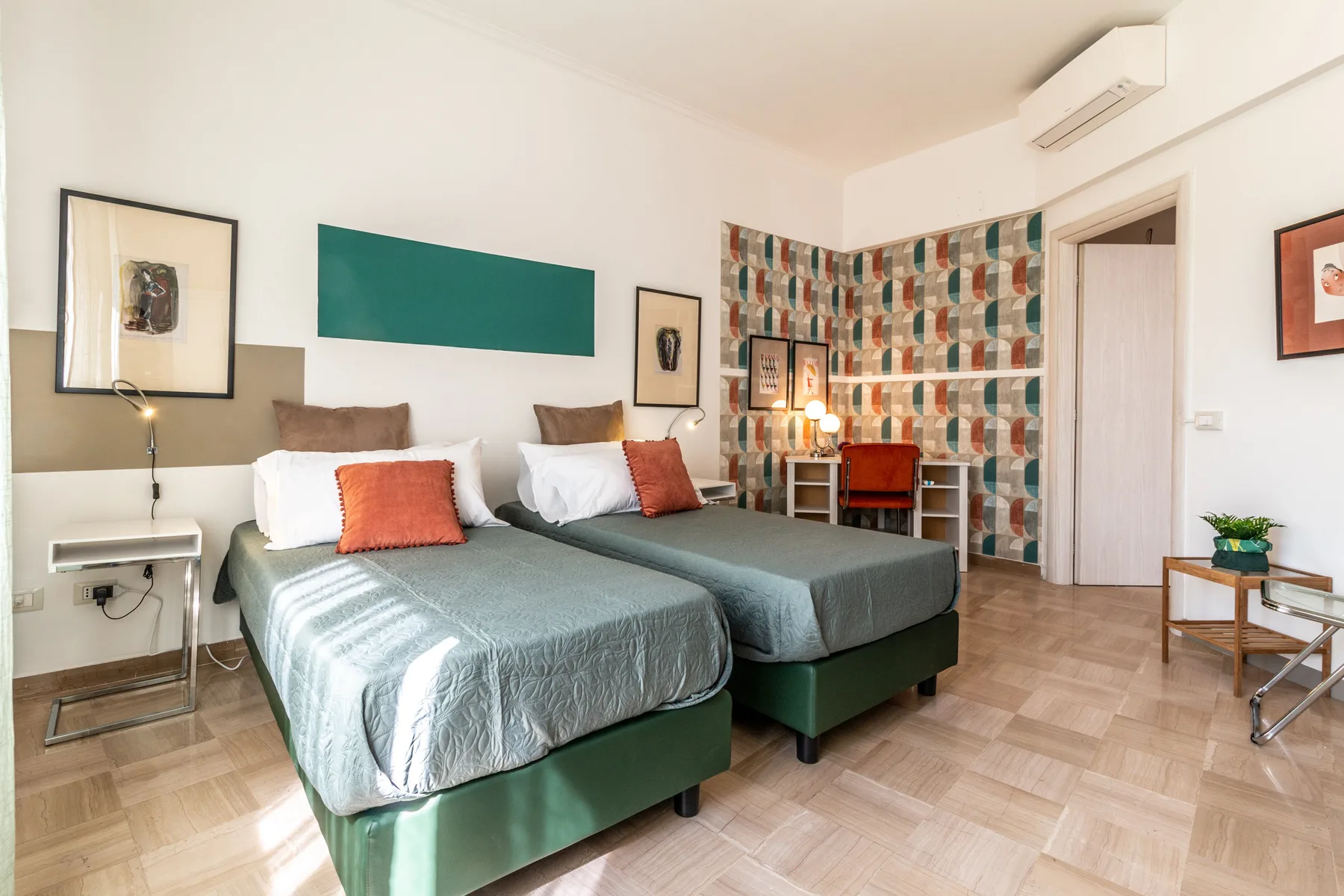 Un dormitorio con dos camas, un escritorio y cortinas estampadas.