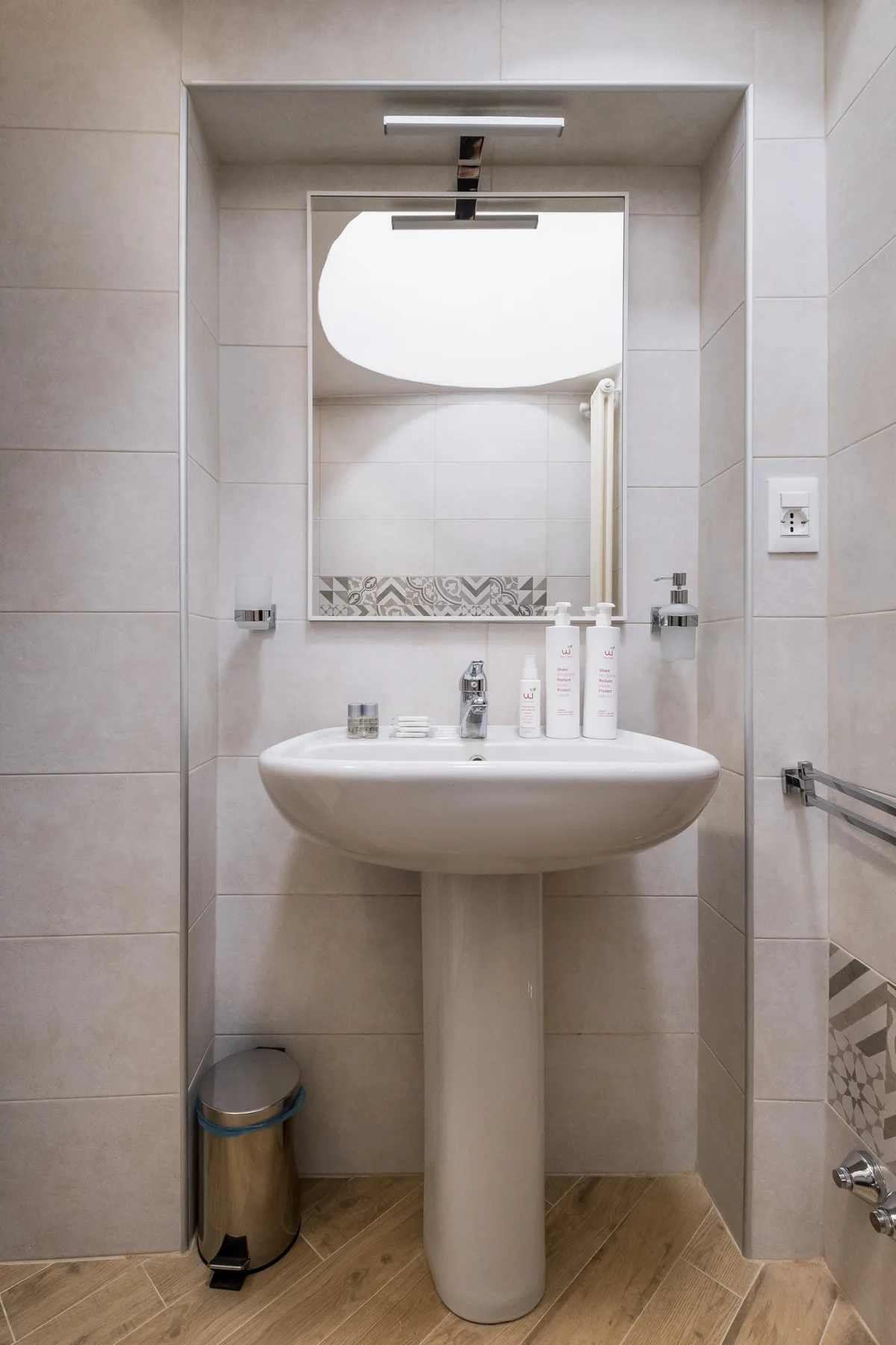 Un lavabo de pedestal con espejo en un baño.