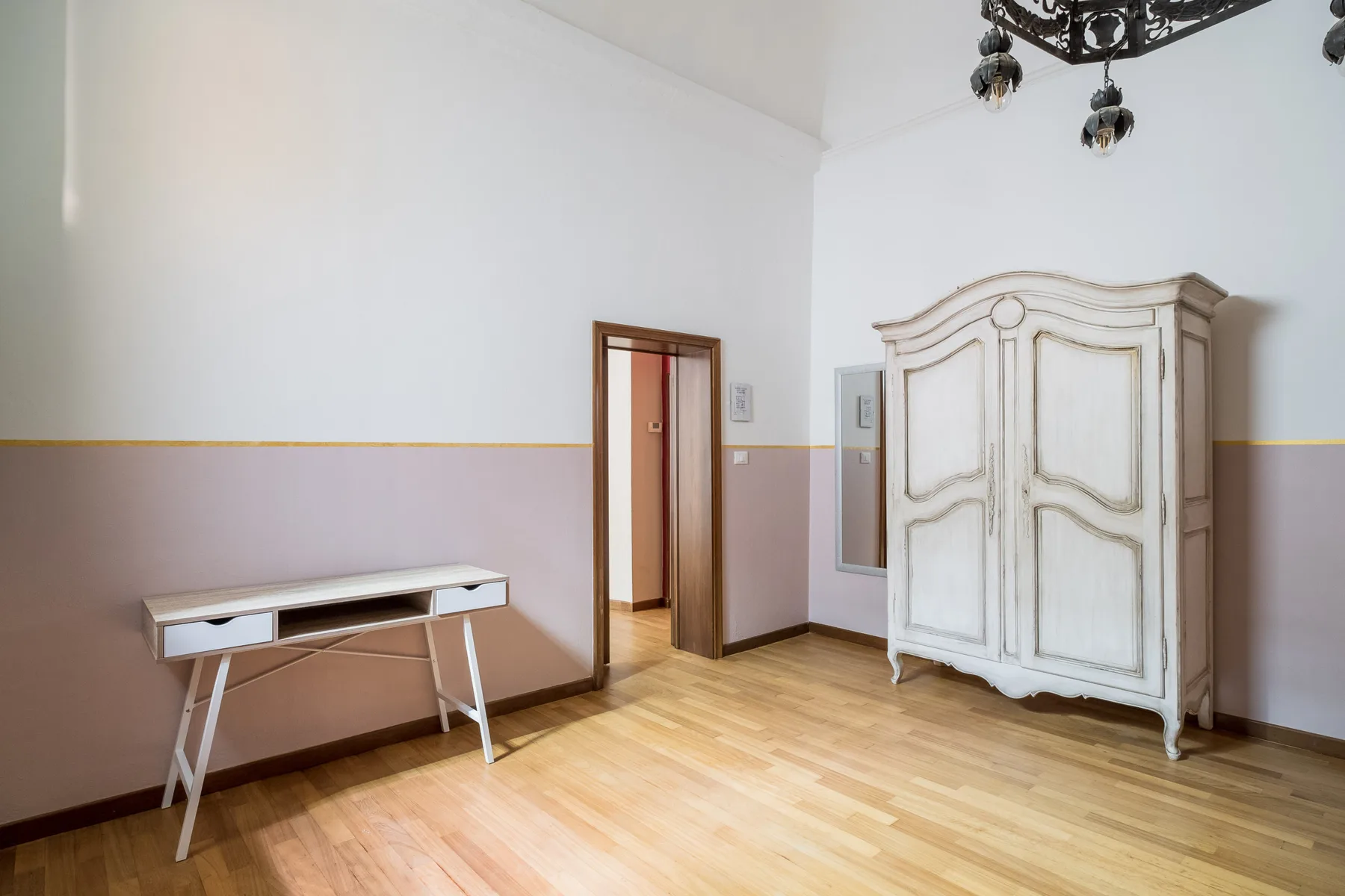 Un dormitorio luminoso con un armario grande y una mesa pequeña.