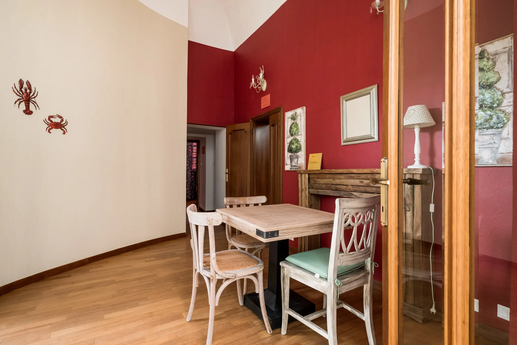 Un comedor con una mesa de madera y sillas junto a paredes rojas.