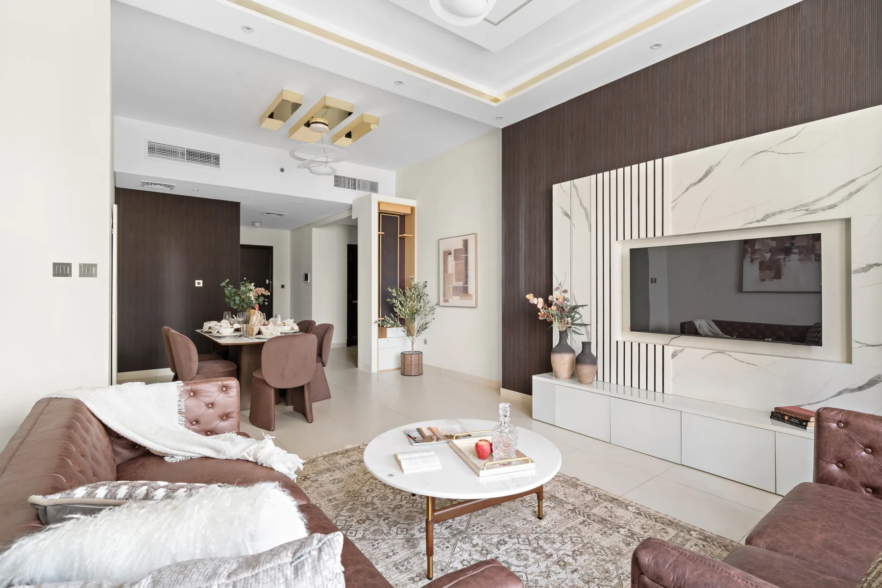 A living room with seating, a coffee table, and a television.