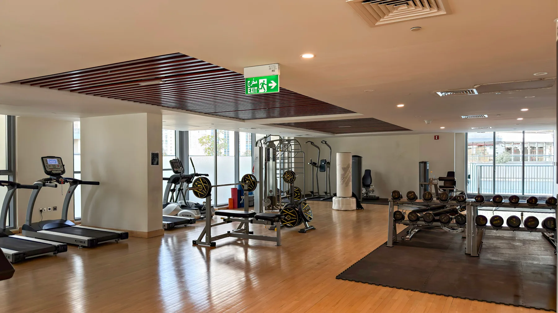 Un gimnasio con cintas de correr, máquinas de ejercicio y una zona de pesas.