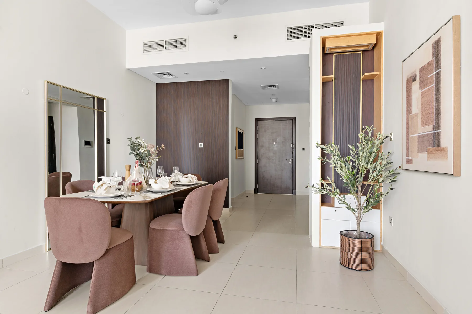 Un comedor con la mesa puesta y asientos tapizados.
