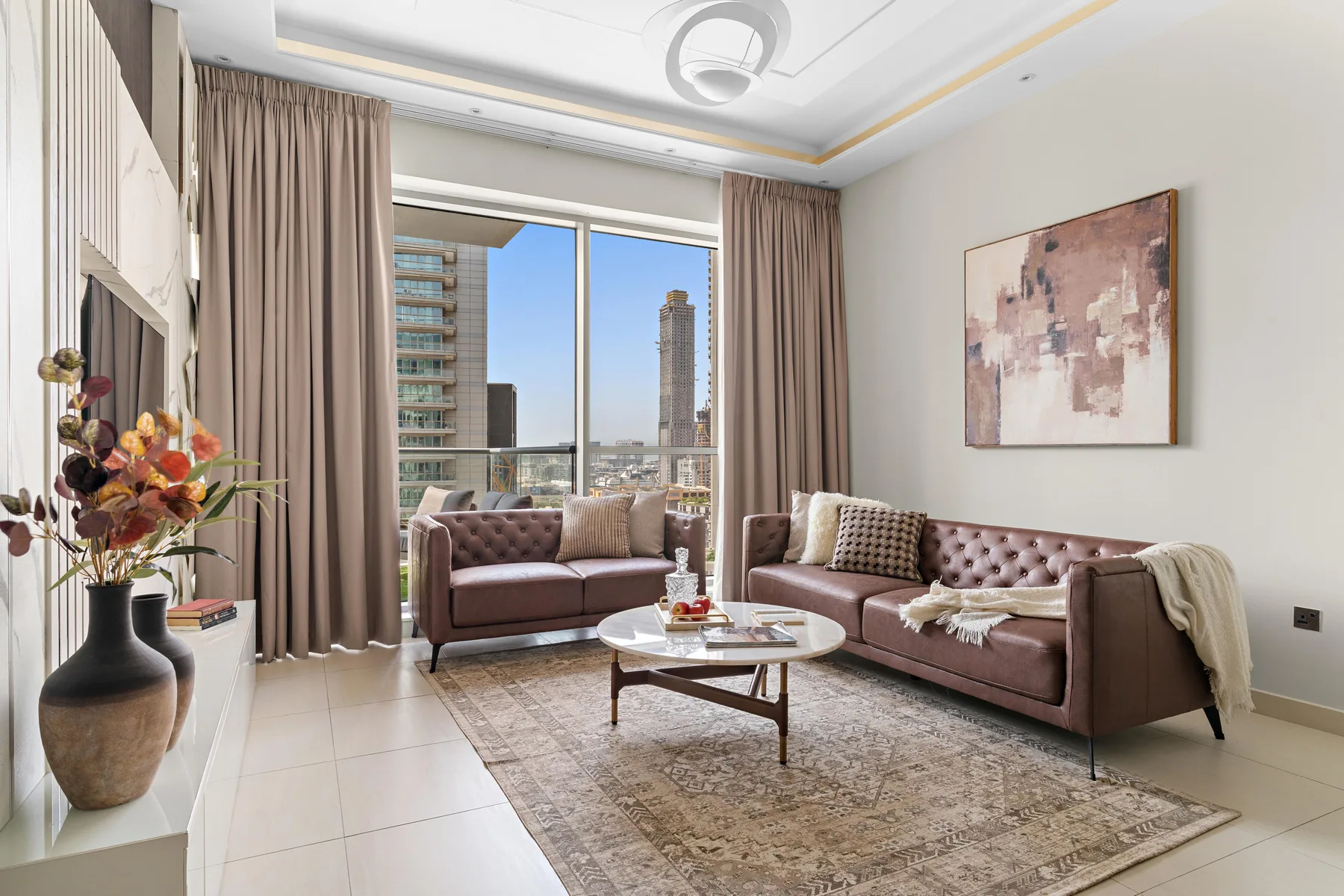 A living room with mauve seating, a coffee table, and large windows.